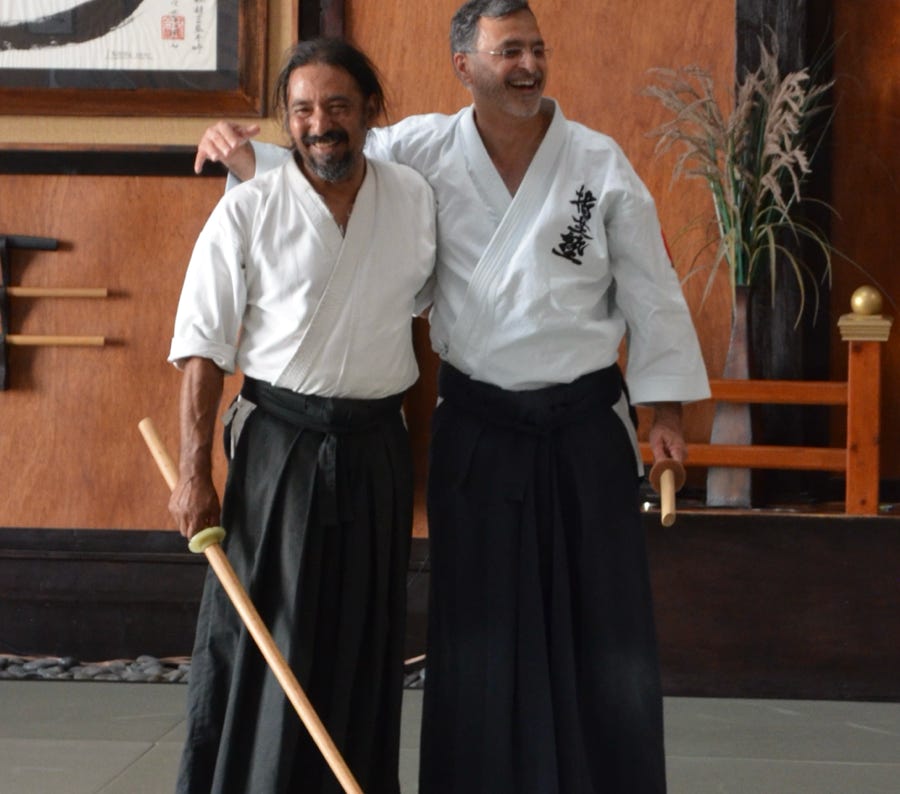Four judo practitioners in gis sit together, showcasing teamwork and martial arts discipline.